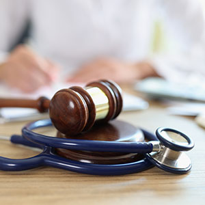 A gavel and stethoscope on a desk, symbolizing medical-legal personal injury.