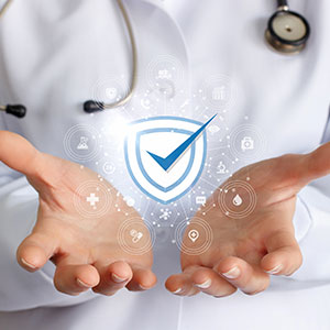 A doctor holding a holographic blue shield with a checkmark and medical icons.
